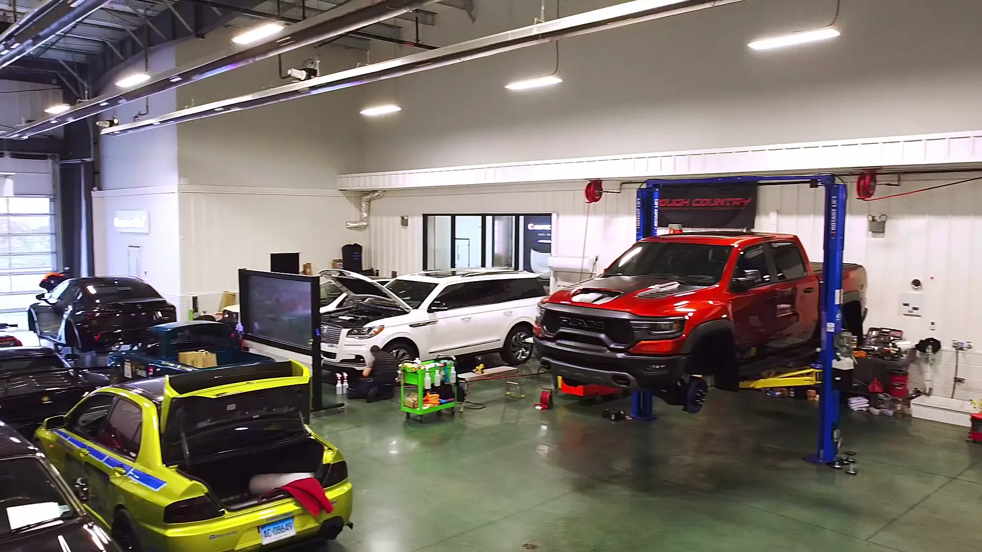 The Castro Oasis install bay, two post lifts and several vehicles in work.